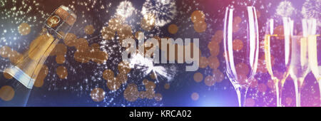 White fireworks exploding on black background against three full glasses of champagne and one empty Stock Photo