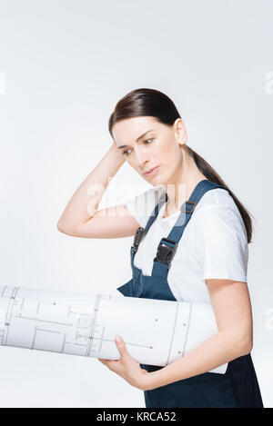 Enthusiastic female architect  thinking about blueprint  Stock Photo