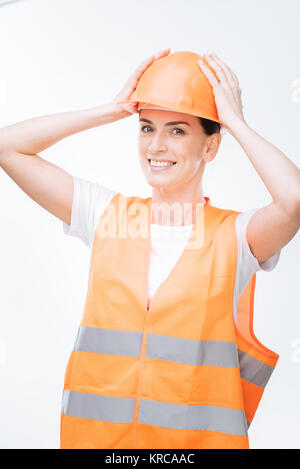 Joyful  female worker fitting in hard hat Stock Photo