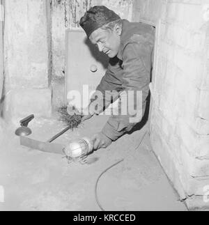 Chimney sweep crawling out of a chimney, Finland, 1958 Stock Photo