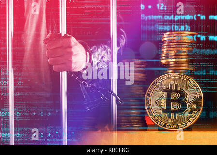 Handcuffed arrested Bitcoin thief in jail, conceptual image Stock Photo