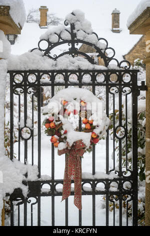 Christmas wreath on a gate in front of a cotswold stone house in december. Chipping Campden, Cotswolds, Gloucestershire, England Stock Photo