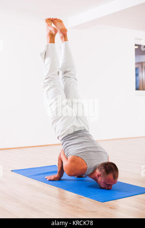 Adult man practicing yoga, Mayurasana / Peacock pose Stock Photo