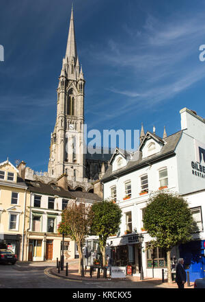 Cork, Ireland - September 15, 2016: The dominating form of St Colman's Cathedral rises above the terraced streets and colourful houses of the small to Stock Photo