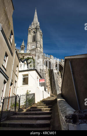 Cork, Ireland - September 15, 2016: The dominating form of St Colman's Cathedral rises above the terraced streets and colourful houses of the small to Stock Photo