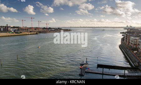 The River Itchen flows into Southampton Water between apartment buildings and construction sites in the city of Southampton. Stock Photo