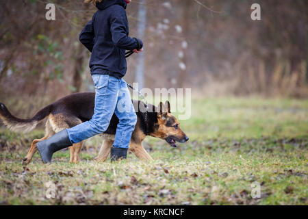 Master and her obedient (German shepherd) dog Stock Photo