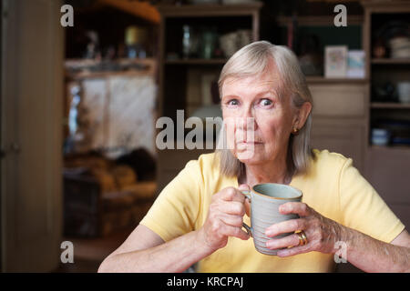 Angry mature woman holding cup Stock Photo