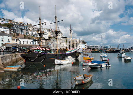 A full sized replica of Sir Francis Drake's Golden Hind, with a few smaller boats, in the harbour at Brixham, Devon.  The ship operates as a museum, in the area where Drake lived and worked. Stock Photo