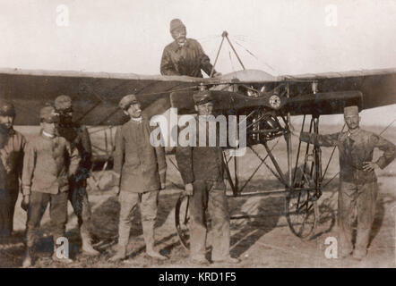 Italian army aviators during the Italo-Turkish War (1911-12) -- the first use of aeroplanes in warfare.  Captain Piazzi sits in his monoplane, about to ascend to reconnoitre the Turkish positions outside Tripoli.  Later news was that Piazzi had been shot at while flying over the enemy, and the wings of his plane were riddled by bullets.      Date: 1912 Stock Photo