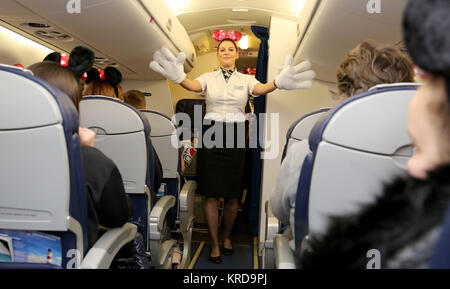 British Airways cabin crew member Kristina Phillips wears Disney hands and ears during the safety announcement to young people and their families who were affected by the Manchester Arena bombing, on a Charity Disney flight to Disneyland Paris. Stock Photo