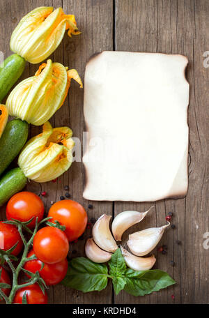 Zucchini with flowers, tomatoes,  basil, garlic and pepper on dark wood Stock Photo