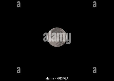 Full moon over dark black sky at night Stock Photo