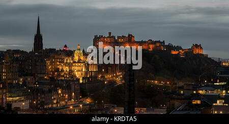 Over looking Edinburgh city at dusk with Edinburgh Castle on top of Castle rock lite up in the distance as viewed from Carlton Hill. Stock Photo