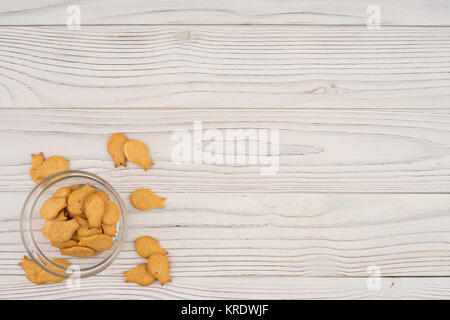 Goldfish cracker in a glass bowl on a white wooden table. Stock Photo