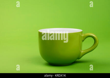 One full big coffee tea cup over green paper Stock Photo