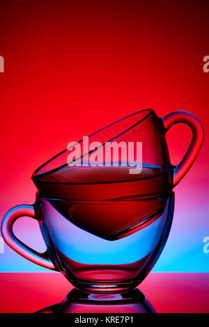 Two Glass cups of Tea over colored red background Stock Photo
