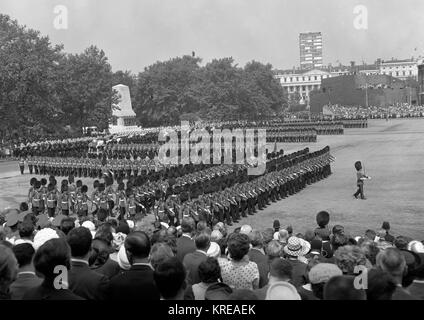 The Guards wheel into line for the march past Queen Elizabeth II at the conclusion of the Trooping the Colour ceremony on the Horse Guards Parade, London. Background, the Household Cavalry wait their turn to pass the Queen. The parade ground is flanked by the Guards Memorial. Stock Photo