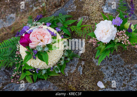 Wedding cake on river rock with native species plants and flowers at a North Umpqua River elopement wedding in Oregon. Stock Photo