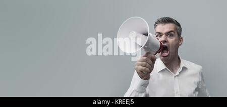 Aggressive man shouting with a megaphone and spreading his message, advertising and communication concept Stock Photo