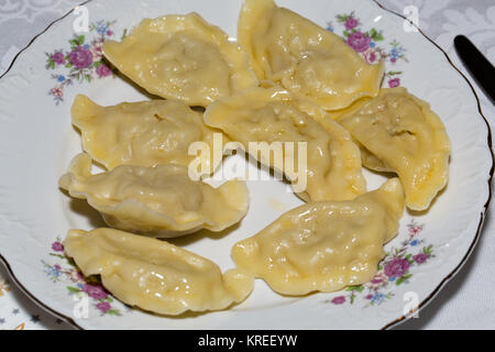 Dumplings filled cheese, cabbage and potatoes adorned bacon Stock Photo