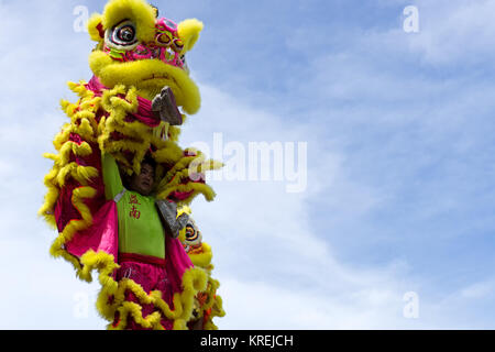 Kota Kinabalu, Malaysia - February 18, 2017: Dancer against blue sky during a dragon dance performance during Chinese new Year season in Sabah Borneo. Stock Photo