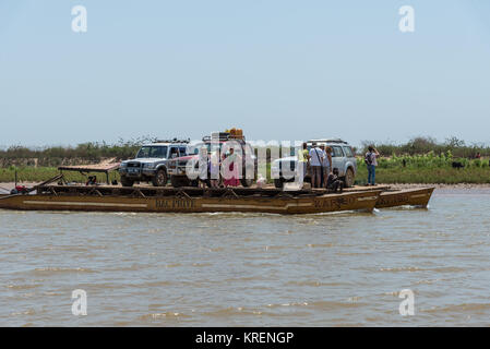 SUVs and passengers on board of a ferry boat on Mania River. Madagascar, Africa. Stock Photo