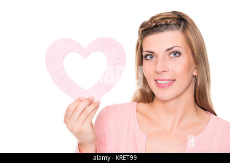 Porträt einer jungen Frau mit rosa Herz vor weißem Hintergrund Stock Photo