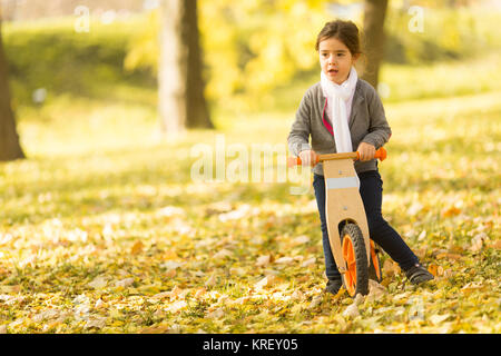 View at little girl riding bicycle in autumn park Stock Photo