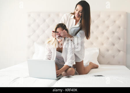 Two beautiful young girls having fun on bed Stock Photo