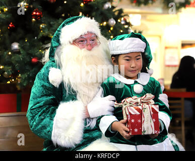 Tokyo, Japan. 19th Dec, 2017. Green Santa Claus smiles with little girl in green suits as he visits the Kidzania career theme park in Tokyo on Tuesday, December 19, 2017. Green Santa Claus from Denmark is now in Japan as a ecology goodwill ambassador. Credit: Yoshio Tsunoda/AFLO/Alamy Live News Stock Photo