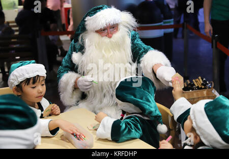 Tokyo, Japan. 19th Dec, 2017. Little Santa Claus 'trainees' wear green suits as they learn how to work for an ecological friendly Green Santa Claus (R) at the Kidzania career theme park in Tokyo on Tuesday, December 19, 2017. Green Santa Claus from Denmark is now in Japan as a ecology goodwill ambassador. Credit: Yoshio Tsunoda/AFLO/Alamy Live News Stock Photo