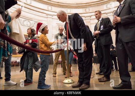 Washington, United States Of America. 19th Dec, 2017. U.S. Vice President Mike Pence, center, greets a young tourist as he walks through the U.S. Capitol Rotunda on his way to the House of Representatives before the vote on the Tax Cut bill December 19, 2017 in Washington, DC. Credit: Planetpix/Alamy Live News Stock Photo