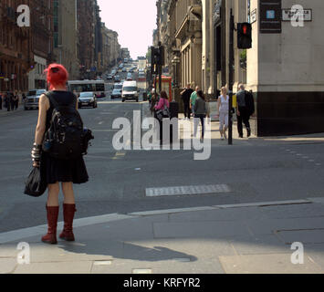 strange girl woman on street corner with red hair people walking sunny everyday British street scene Gordon Street Glasgow Stock Photo