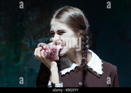 Bloody Halloween theme: crazy girl with raw meat Stock Photo