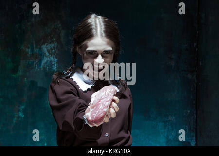 Bloody Halloween theme: crazy girl with raw meat Stock Photo