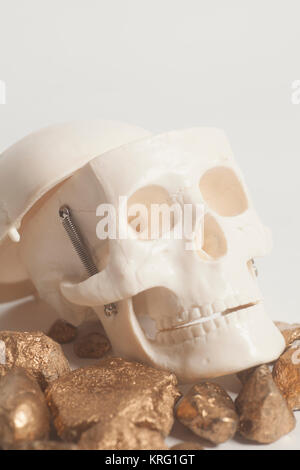 Golden nuggets with skull head on white background Stock Photo