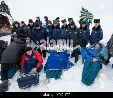 Expedition 38 Flight Engineer Sergey Ryazanskiy of the Russian Federal Space Agency, Roscosmos, left, Commander Oleg Kotov of Roscosmos, center, and, Flight Engineer Mike Hopkins of NASA, sit in chairs outside the Soyuz TMA-10M capsule shortly after they landed in a remote area near the town of Zhezkazgan, Kazakhstan, on Tuesday, March 11, 2014. Hopkins, Kotov and Ryazanskiy returned to Earth after five and a half months on the International Space Station. Photo Credit: (NASA/Bill Ingalls) Soyuz TMA-10M crew shortly after landing Stock Photo