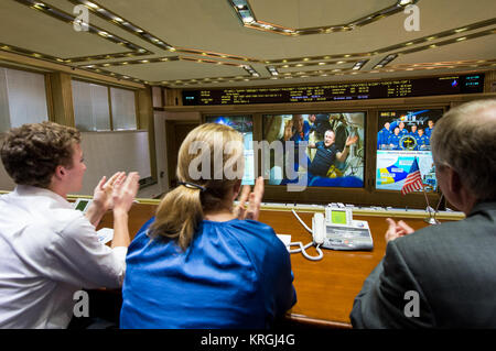 Expedition 39 Flight Engineer Oleg Artemyev of the Russian Federal Space Agency, Roscosmos, left, is seen on the TV screen at the Russian Mission Control Center in Korolev, Russia a few hours after the Soyuz TMA-12M docked to the International Space Station on Friday, March 28, 2014.  Artemyev boarded the ISS with fellow crew members Soyuz Commander Alexander Skvortsov of Roscosmos, and Flight Engineer Steve Swanson of NASA. The crew of three launched at 3:17 a.m. Kazakhstan time on Wednesday, March 26 from the Baikonur Cosmodrome in Kazakhstan. Photo Credit: (NASA/Joel Kowsky) Expedition 39 D Stock Photo