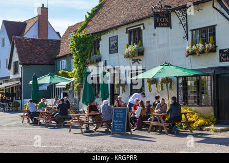 Drinkers sit outside the Fox Inn in the summer sun, Finchingfield, Essex, UK Stock Photo