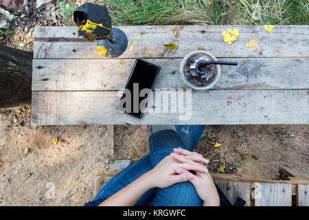 relax time with mobile phone and cold drink on wooden table lifestyle in nature Stock Photo