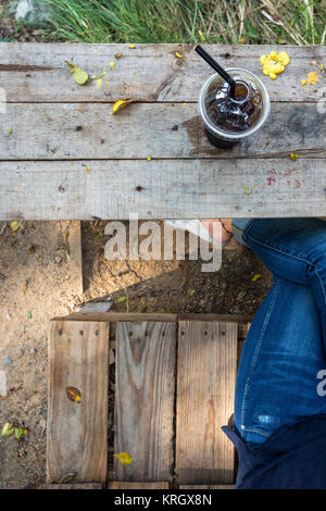 leg with jean asian girl relax time with cold drink on wooden table lifestyle in nature Stock Photo