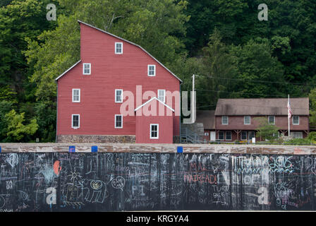 Red Mill behind a Wall of Graffiti Stock Photo
