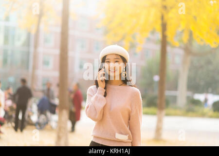 Teenage Girl Making Mobile Phone Call In Autumn Landscape Stock Photo