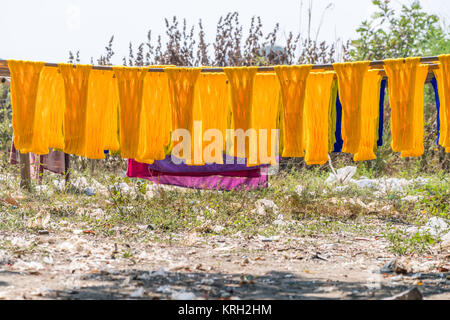 Colorful cotton yarn drying on a stick , in Mandalay near U bein brigde, Myanmar , Asia Stock Photo