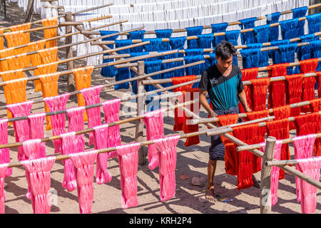 People and Colorful cotton yarn drying on a stick , in Myanmar , Asia. Near U Bein Bridge Stock Photo