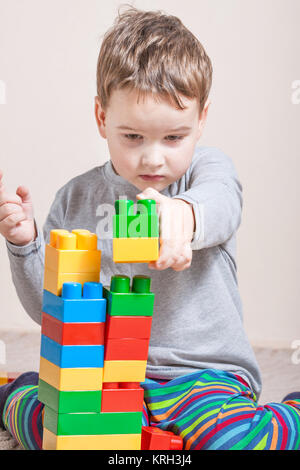 Playing little boy with colored cubes Stock Photo