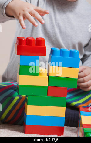 Playing little boy with colored cubes Stock Photo