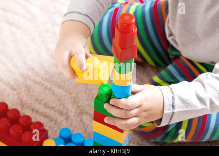 Playing little boy with colored cubes Stock Photo