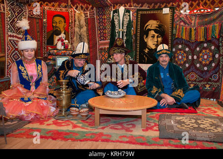14-12-59-00:     (14 Sept. 2014) --- Wearing native Kazakh clothing, Expedition 41/42 backup crewmembers Scott Kelly of NASA (second from left), Gennady Padalka of the Russian Federal Space Agency (Roscosmos, second from right) and Mikhail Kornienko of Roscosmos (far right) enjoy the ambiance of a traditional Kazakh lunch in a “yurt”, or tent, during a tour of Baikonur, Kazakhstan Sept. 14. Kelly and Kornienko will launch from Baikonur in March 2015 to spend a full year on the International Space Station. They are backups to Barry Wilmore of NASA, Alexander Samokutyaev of the Russian Federal S Stock Photo